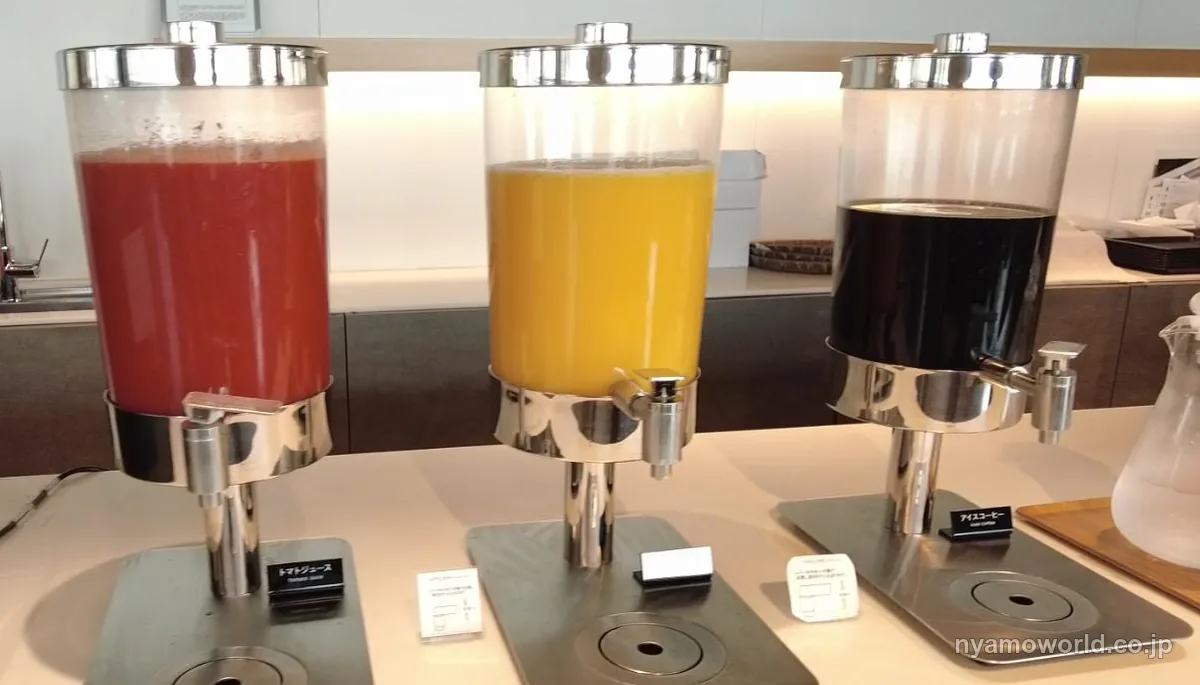 羽田空港のPOWER LOUNGEに並ぶトマトジュース・オレンジジュース・アイスコーヒーのディスペンサー