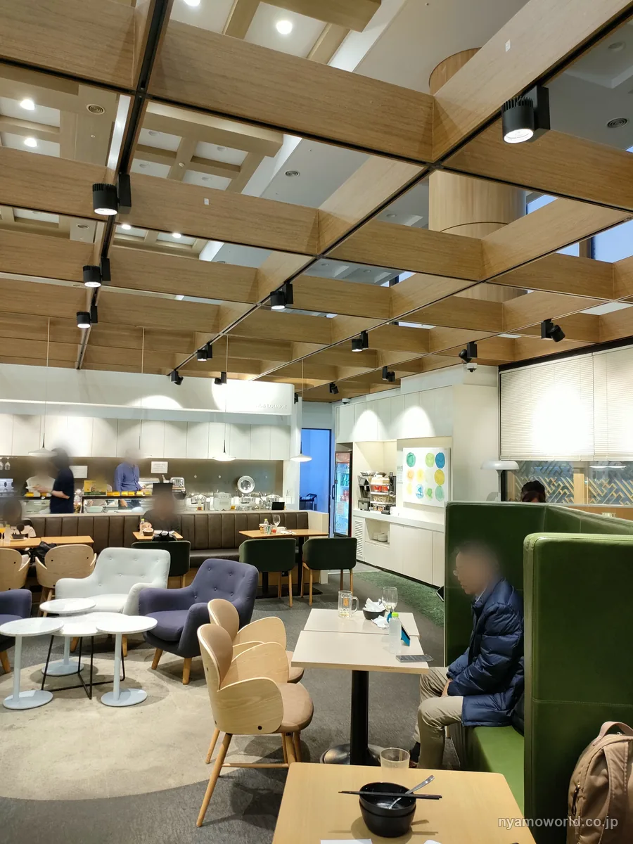 金浦空港Sky Hub Loungeの中。ソファ席とテーブル席、奥にビュッフェカウンター