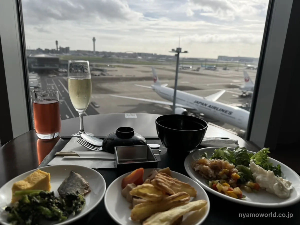 サクララウンジの窓際でJAL機を見ながら取った料理とスパークリングワイン