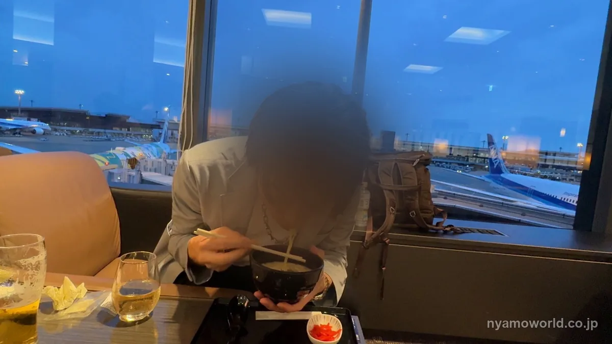 成田空港のファーストクラスのラウンジで出発前に麺を食べる様子